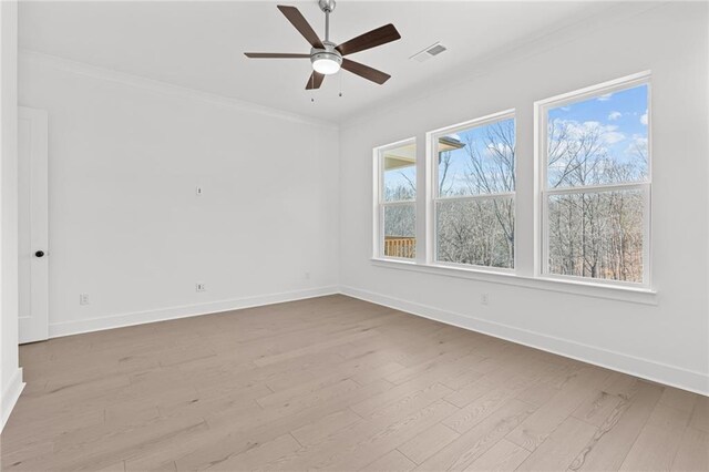 spare room with ornamental molding, ceiling fan, and light wood-type flooring