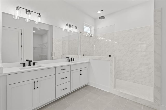 bathroom featuring tiled shower, vanity, and tile patterned flooring