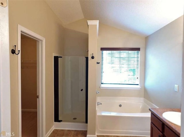 bathroom featuring vanity, lofted ceiling, a textured ceiling, and plus walk in shower