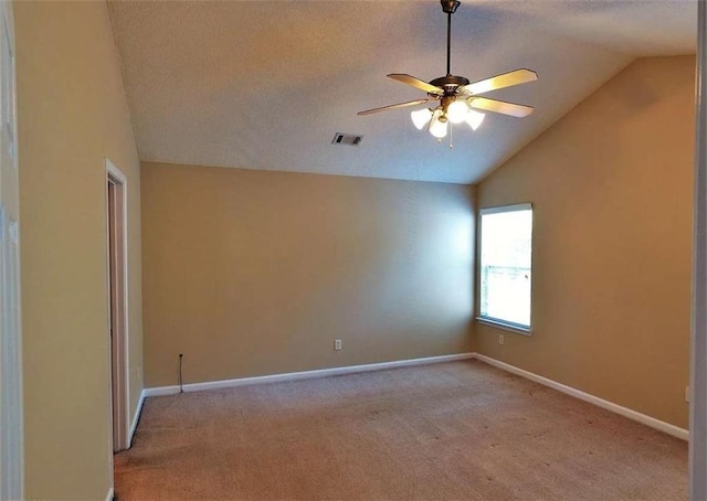 carpeted empty room featuring a textured ceiling, ceiling fan, and lofted ceiling