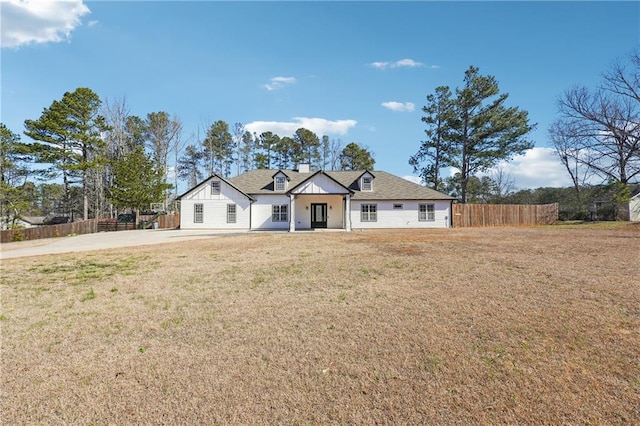 view of front of home featuring fence and a front lawn