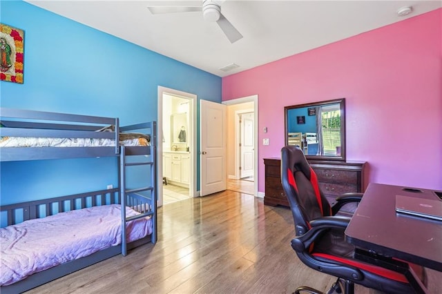 bedroom featuring visible vents, a ceiling fan, wood finished floors, and ensuite bathroom