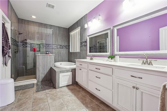 full bath featuring double vanity, visible vents, a stall shower, a sink, and tile patterned floors