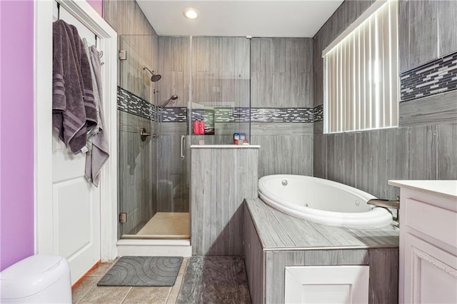 bathroom with toilet, a stall shower, vanity, tile patterned flooring, and a whirlpool tub