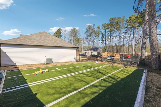 view of yard featuring fence and central air condition unit