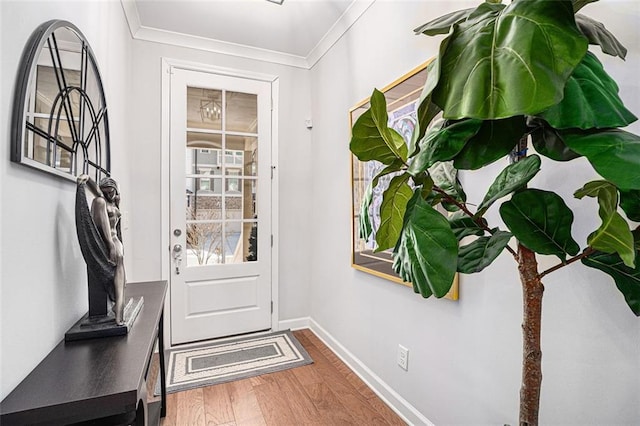 entryway featuring wood finished floors, baseboards, and ornamental molding