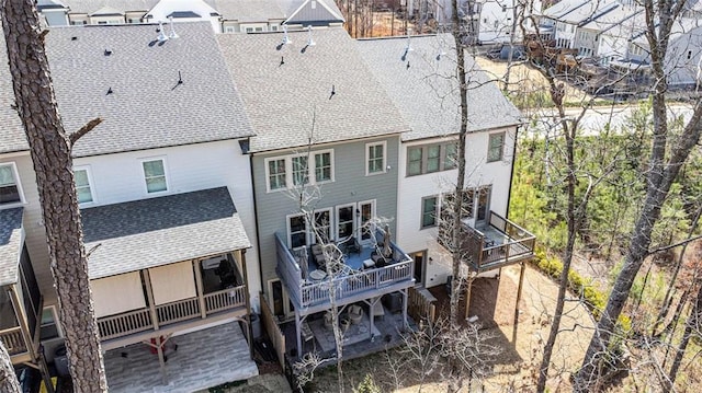 rear view of property featuring a shingled roof