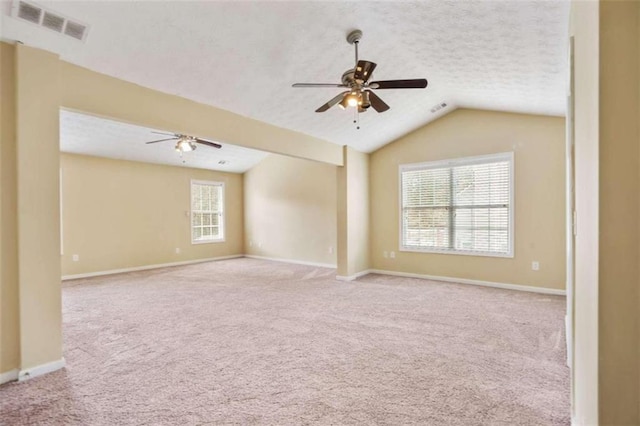 carpeted spare room with vaulted ceiling and ceiling fan