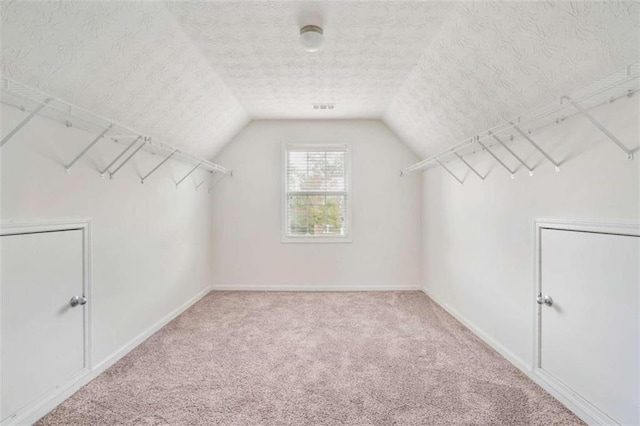 walk in closet featuring lofted ceiling and carpet