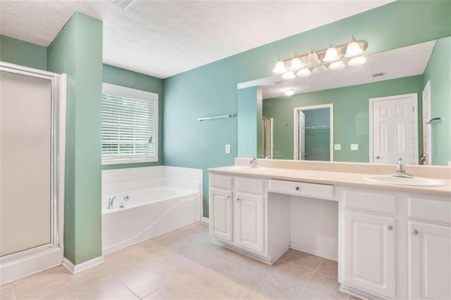 bathroom with a textured ceiling, independent shower and bath, vanity, and tile patterned floors