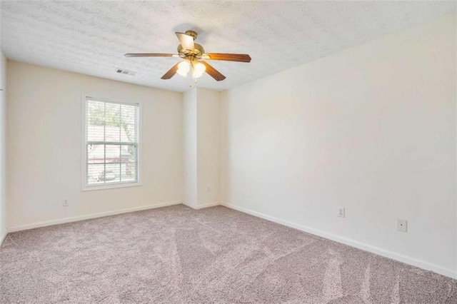 carpeted spare room with ceiling fan and a textured ceiling