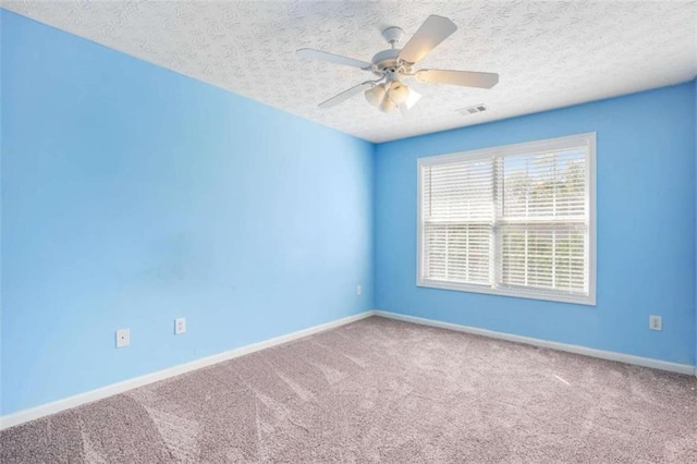 carpeted empty room featuring a textured ceiling and ceiling fan