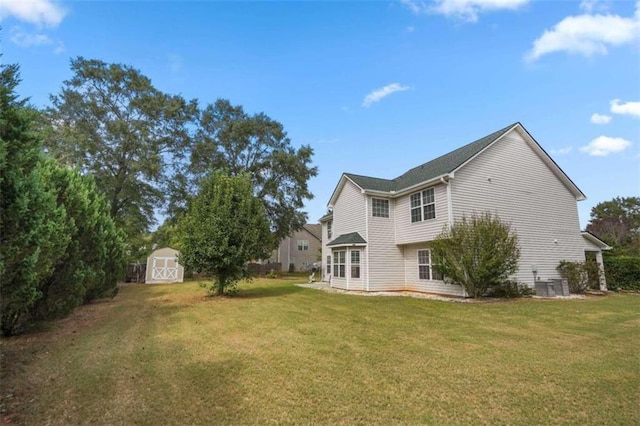 rear view of property featuring a yard and a storage unit