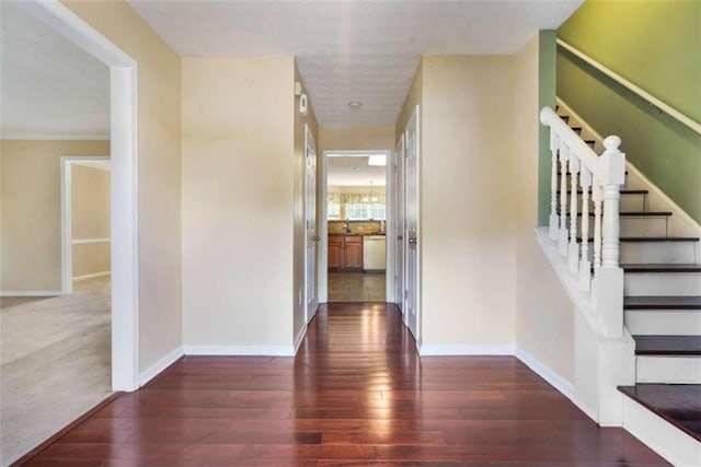 corridor featuring dark wood-type flooring and a chandelier