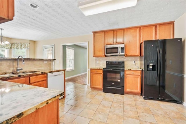 kitchen with decorative backsplash, a wealth of natural light, and black appliances