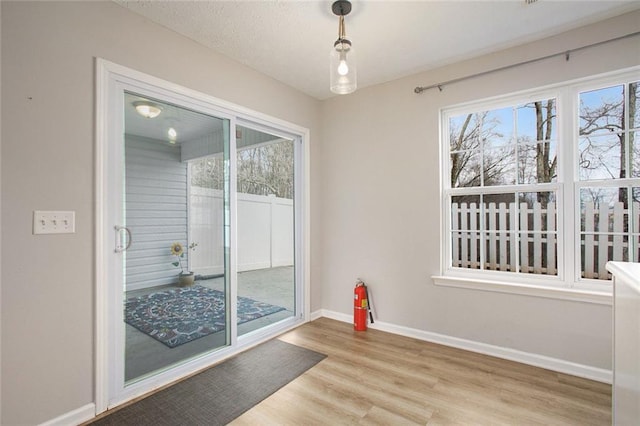 dining space featuring light wood-style floors and baseboards