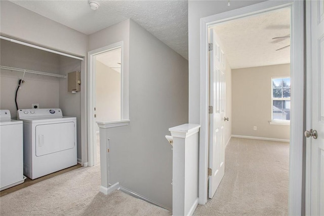 laundry room featuring a textured ceiling, light colored carpet, laundry area, baseboards, and washing machine and clothes dryer