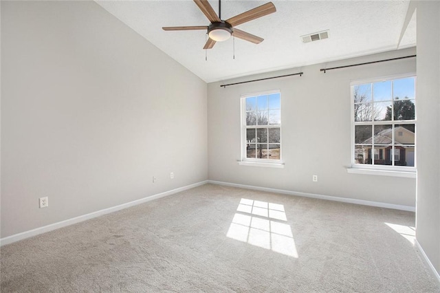 carpeted spare room featuring a healthy amount of sunlight, visible vents, ceiling fan, and baseboards