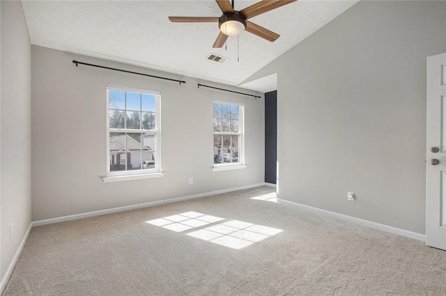 unfurnished room with light carpet, lofted ceiling, visible vents, and baseboards