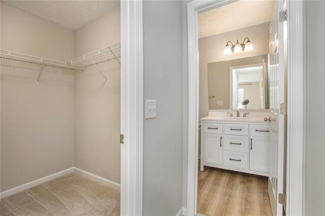 bathroom with a textured ceiling, vanity, and baseboards