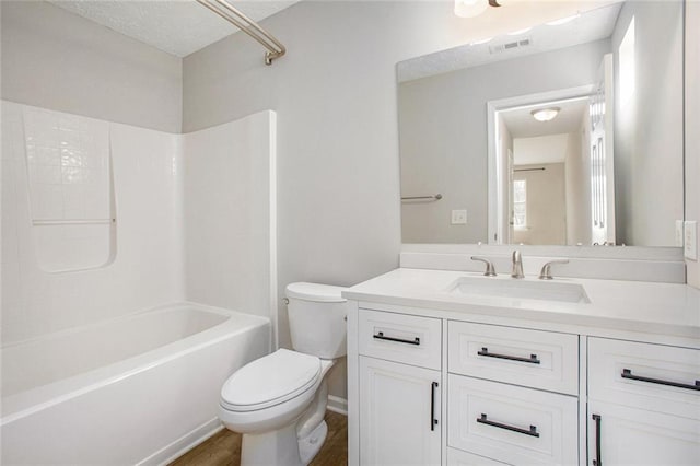 bathroom featuring shower / bathtub combination, visible vents, toilet, vanity, and wood finished floors