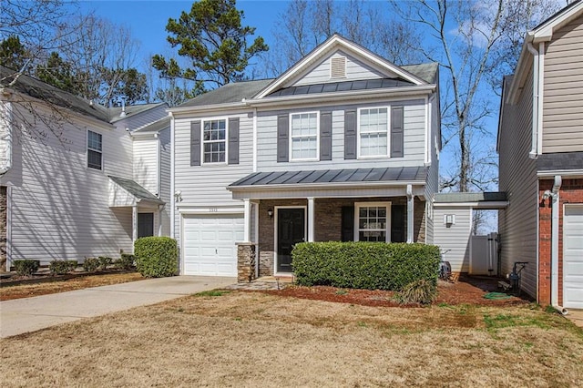 view of front facade featuring concrete driveway, metal roof, a standing seam roof, covered porch, and a front yard