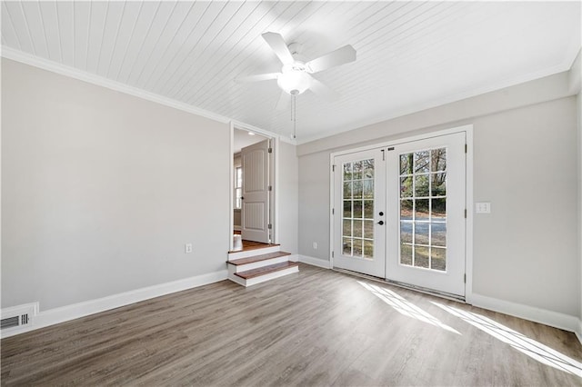 empty room featuring french doors, visible vents, crown molding, and wood finished floors