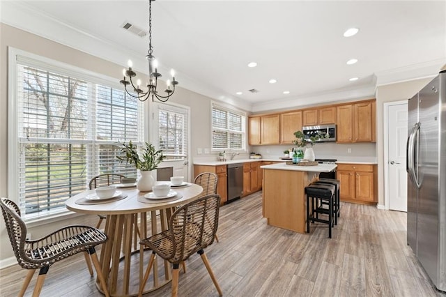 kitchen featuring visible vents, a kitchen island, light countertops, appliances with stainless steel finishes, and a notable chandelier