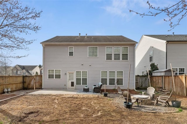 back of property with a patio, a fenced backyard, and an outdoor fire pit