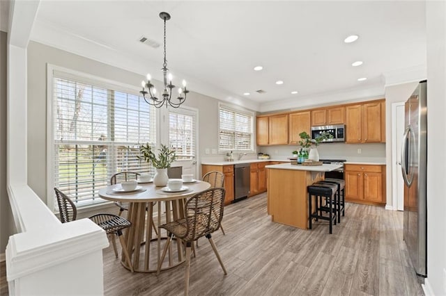 kitchen with visible vents, a center island, light countertops, appliances with stainless steel finishes, and an inviting chandelier