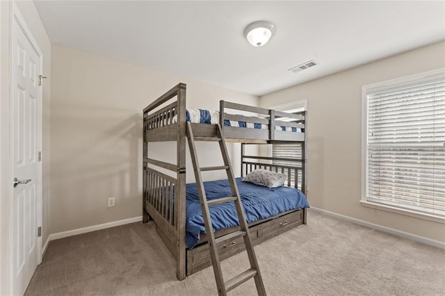 carpeted bedroom featuring visible vents, baseboards, and multiple windows