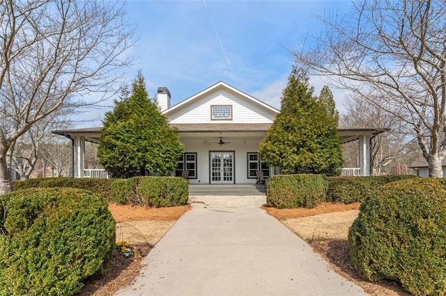 view of front of house with a porch, french doors, a chimney, and ceiling fan