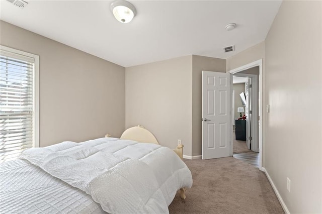 carpeted bedroom with visible vents and baseboards