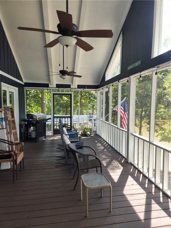 sunroom / solarium featuring vaulted ceiling, ceiling fan, and a healthy amount of sunlight