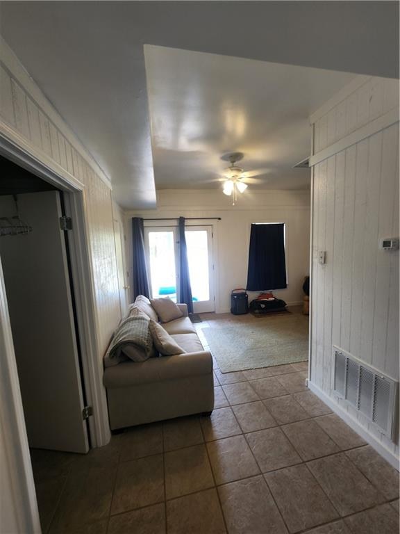 tiled living room featuring ceiling fan