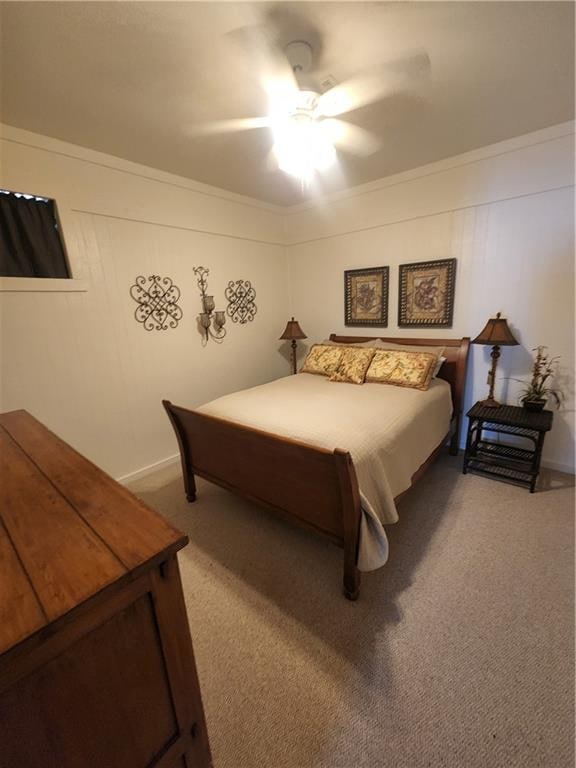 bedroom featuring ceiling fan, crown molding, and carpet flooring