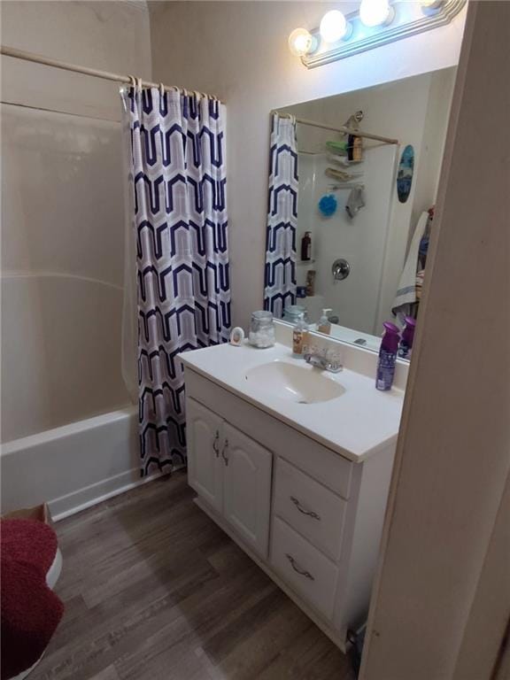 full bath featuring wood finished floors, shower / tub combo, and vanity