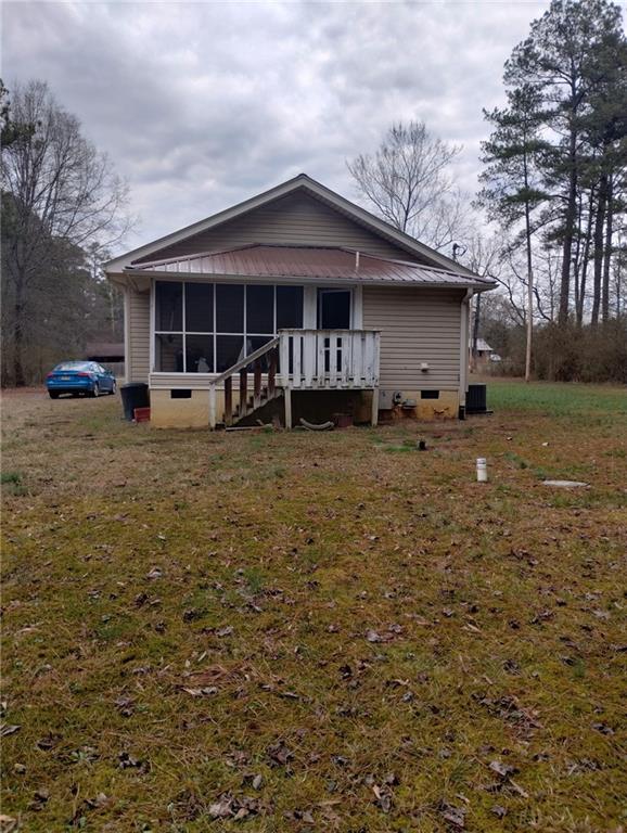 view of front of property with a front lawn, crawl space, and a sunroom