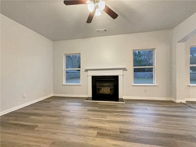 unfurnished living room with dark hardwood / wood-style floors and ceiling fan