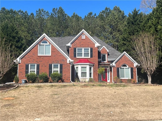 traditional home with brick siding and a front yard