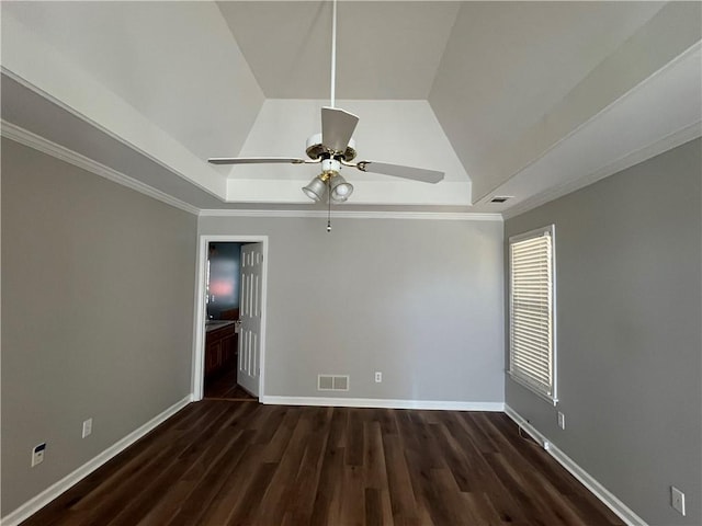 unfurnished room with a tray ceiling, wood finished floors, visible vents, and baseboards