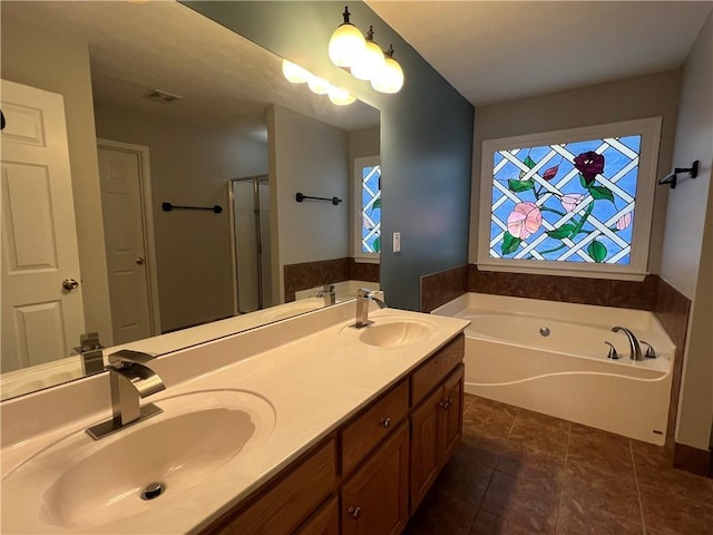 bathroom featuring a garden tub, a sink, and visible vents