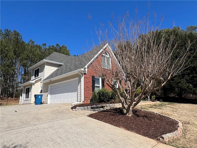 view of property exterior with a garage, roof with shingles, concrete driveway, and brick siding