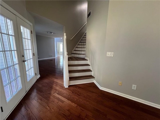 stairway with french doors, visible vents, a healthy amount of sunlight, wood finished floors, and baseboards