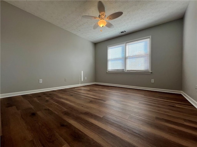 unfurnished room featuring a textured ceiling, ceiling fan, dark wood finished floors, and visible vents