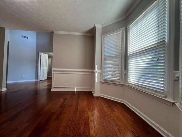 empty room featuring dark wood finished floors, visible vents, ceiling fan, a textured ceiling, and baseboards