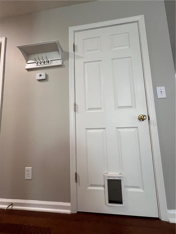 unfurnished bedroom with a textured ceiling, dark wood-type flooring, a closet, and baseboards