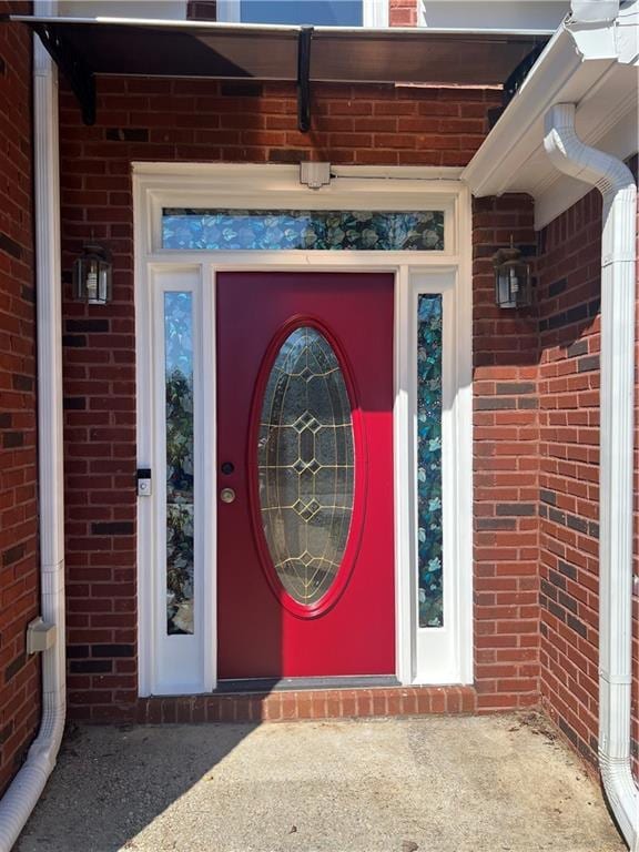 entrance to property featuring brick siding