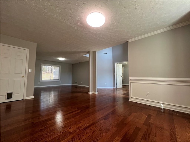 empty room featuring a textured ceiling, baseboards, and wood finished floors