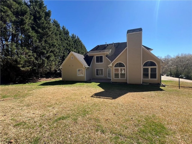 back of property with a yard and a chimney